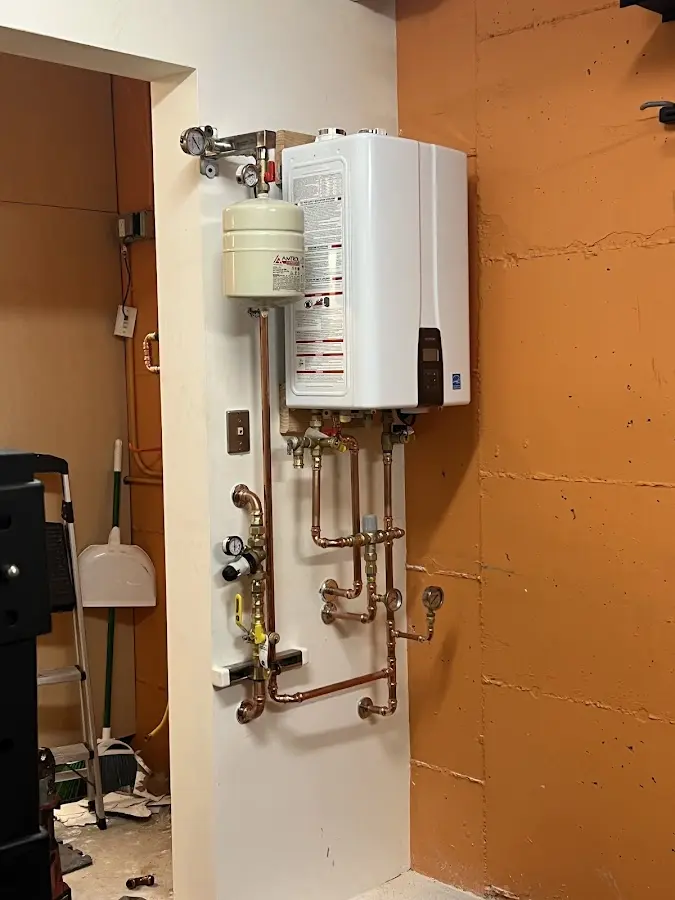 Plumbing technician inspecting water heater connections in Homer